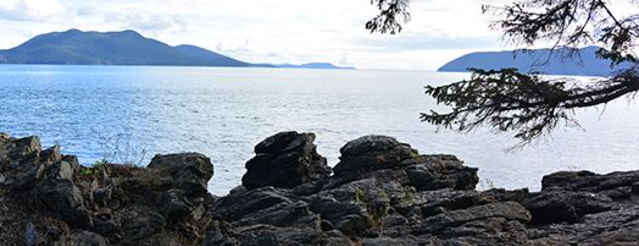 Rocky edge overlooking the ocean with two islands in the distance