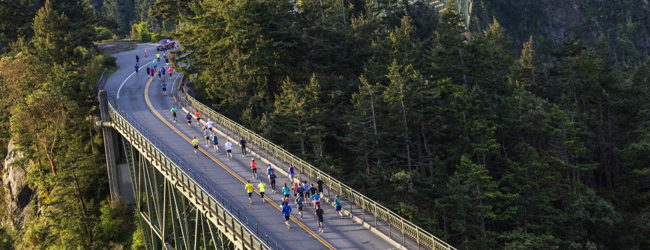 Deception Pass Bridge with marathon runners, running across bridge.