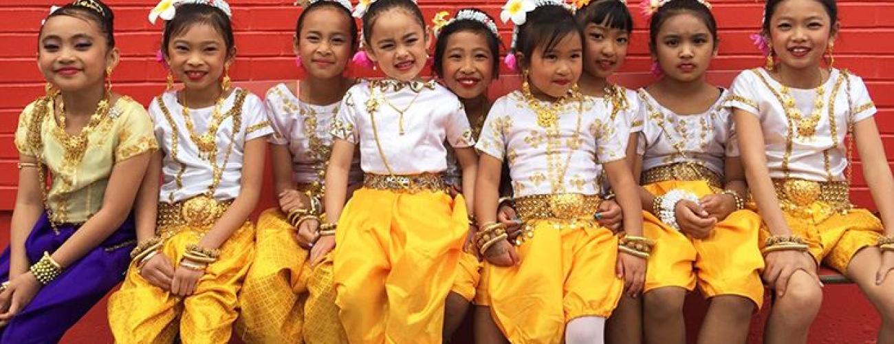 Children at a folk and traditional arts event posing together after dancing