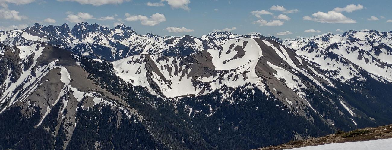 Snowy mountain range sits beyond field of snow