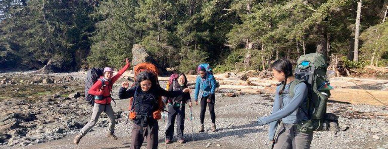 Members of the Emerging Leaders Program smile on the beach during a group backpacking trip