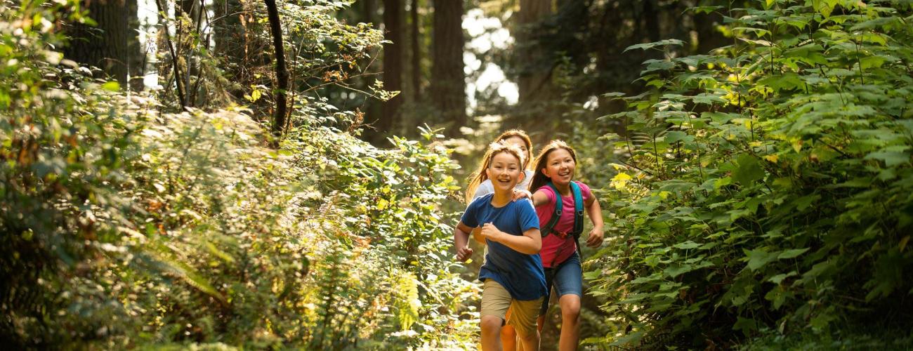 Three children running and playing at a state park