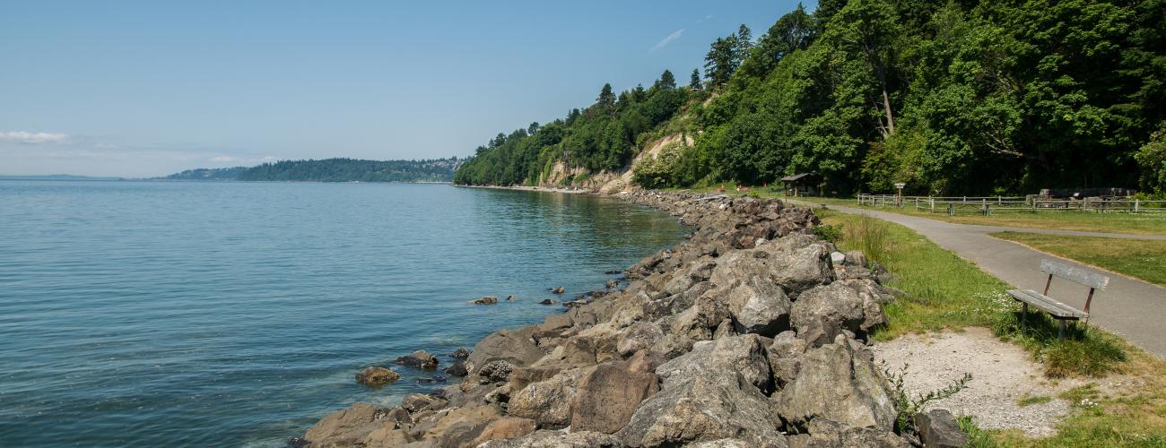 A view of a paved trail along the water at Saltwater State Park