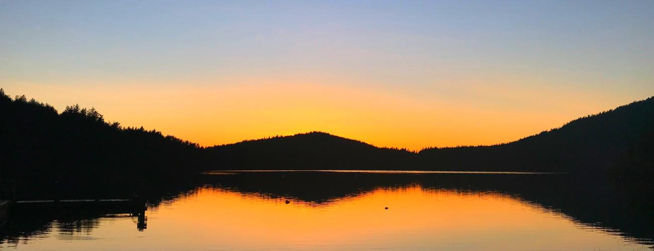 Sunset on lake water with mountains 