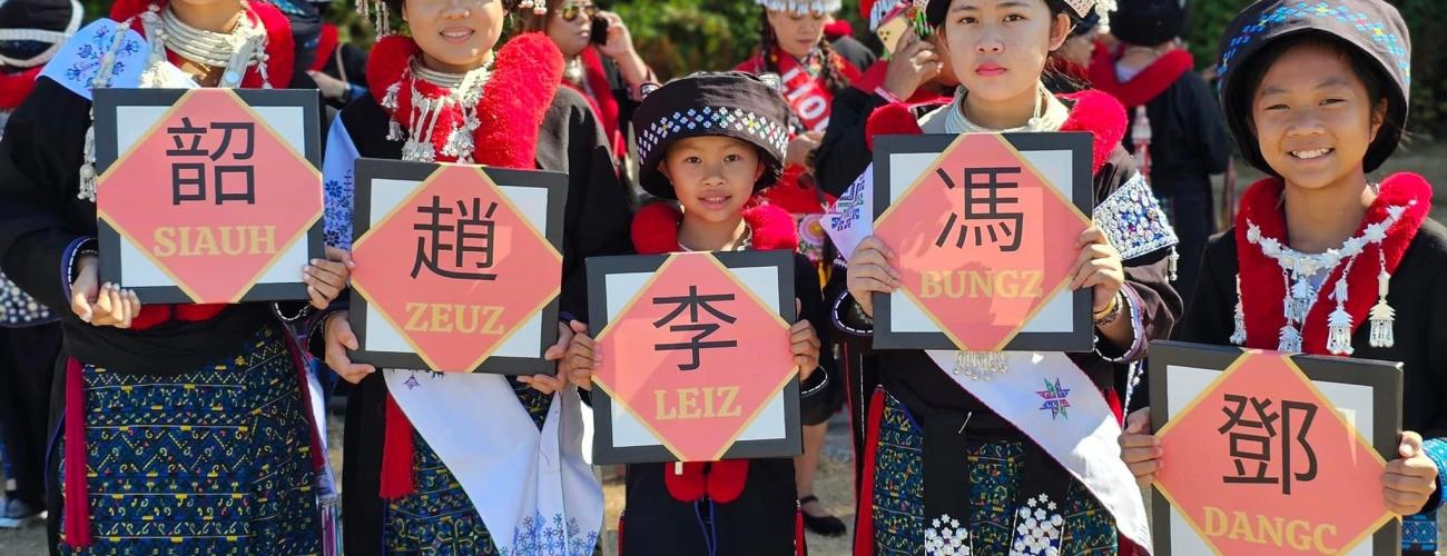 5 Mien female stands up and each of them holds a Chinese characters written on red paper 