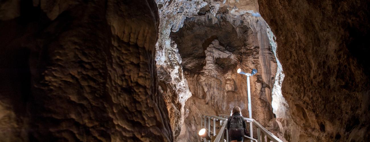 person on walkway inside cave