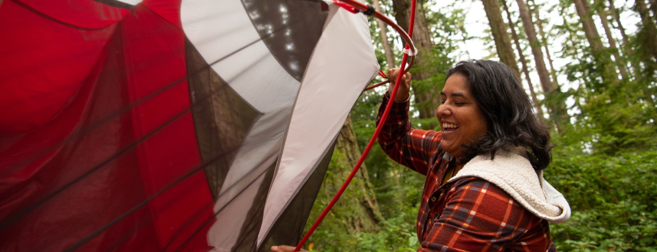 person trying to set up tent at a campsite