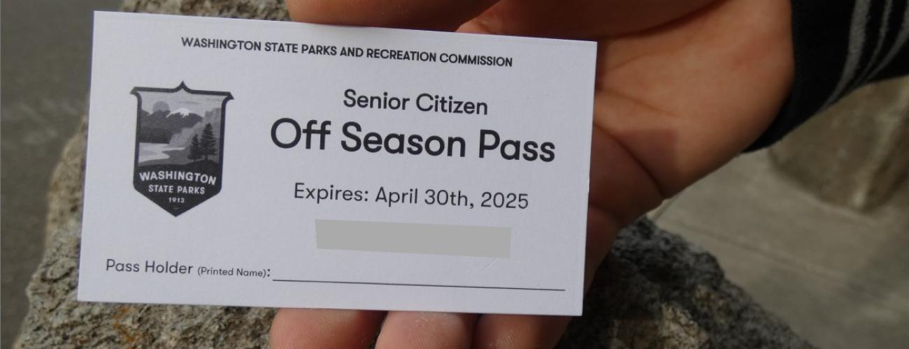 Hand holding a white Senior Off-Season pass.