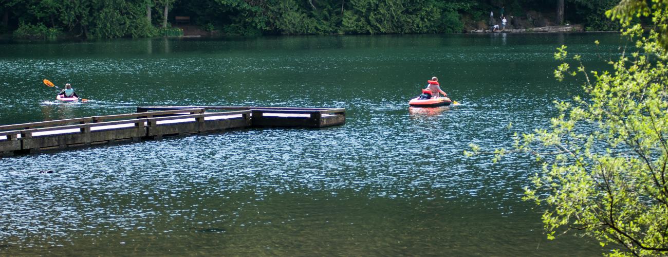 people swimming in deep blue lake water