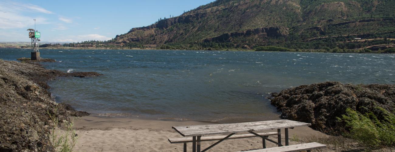 picnic table on beach by river