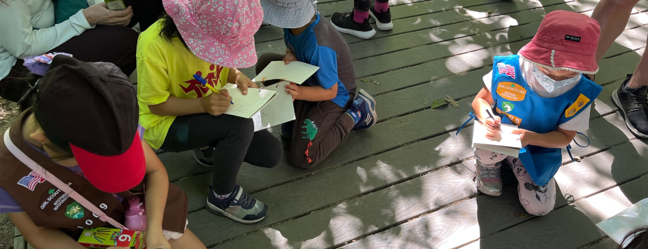 Girl Scouts circled up taking notes while they learn from our interpretive rangers