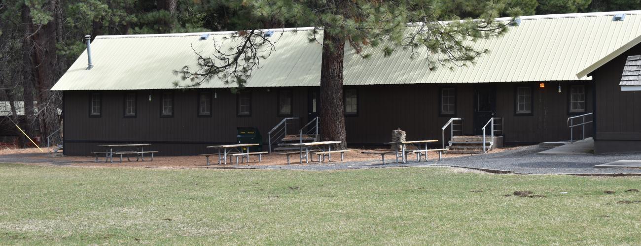 Long wooden building with picnic tables