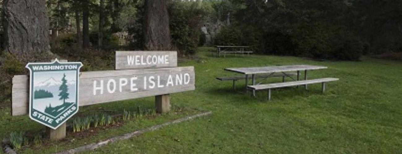 park entrance sign with parks logo next to a picnic table