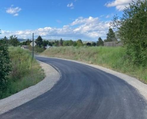 A newly repaved section of the Centennial Trail with fresh gravel along each side.