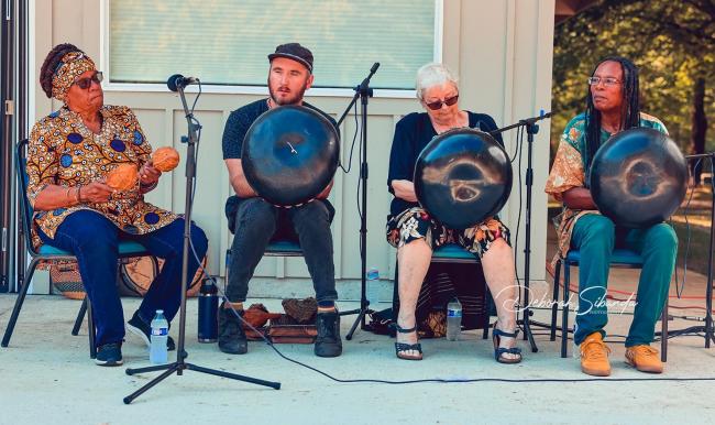 Four musicians play traditional African instruments.