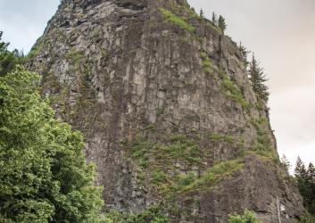 Ranger station with Beacon Rock in the background on a cloudy day.