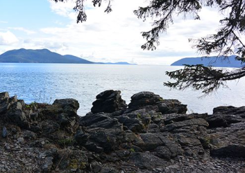 Rocky edge overlooking the ocean with two islands in the distance