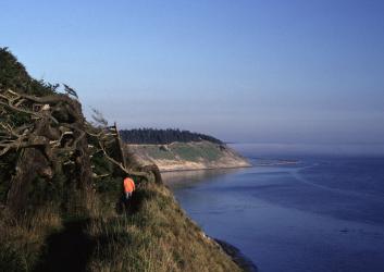 hiker on trail along bluffs above ocean