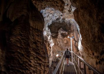 person on walkway inside cave