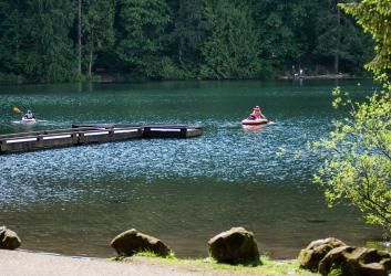 people swimming in deep blue lake water