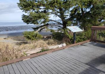 boardwalk with interpretive sign near beach and mudflats