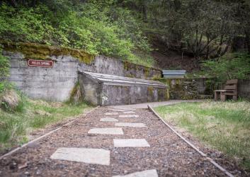 path leading to wooden box sheltering spring water