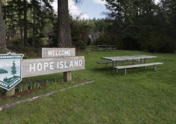 park entrance sign with parks logo next to a picnic table