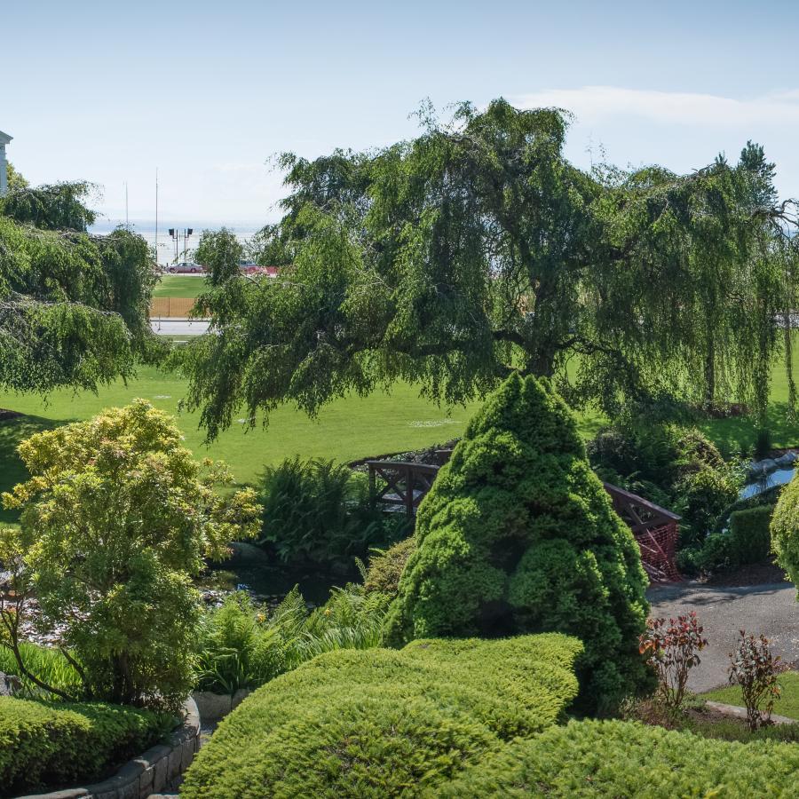 Panorama picture looking over Gazebo, gardens and manicured lawn with the ocean in the distance