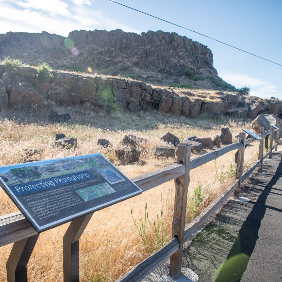 clear view of cliffs along gravel trail with wooden rail