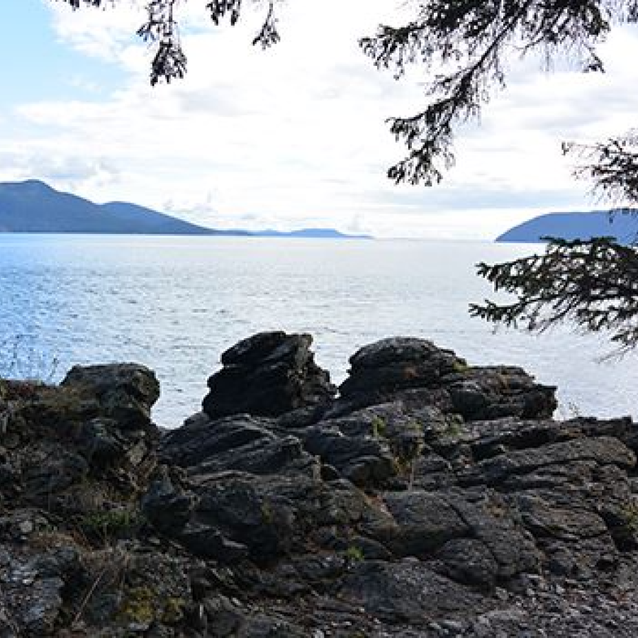 Rocky edge overlooking the ocean with two islands in the distance