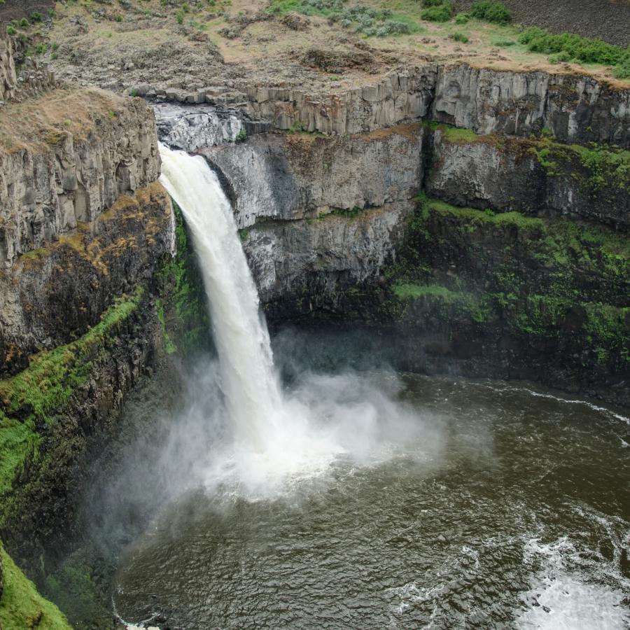 A large waterfall pours over a cliff.