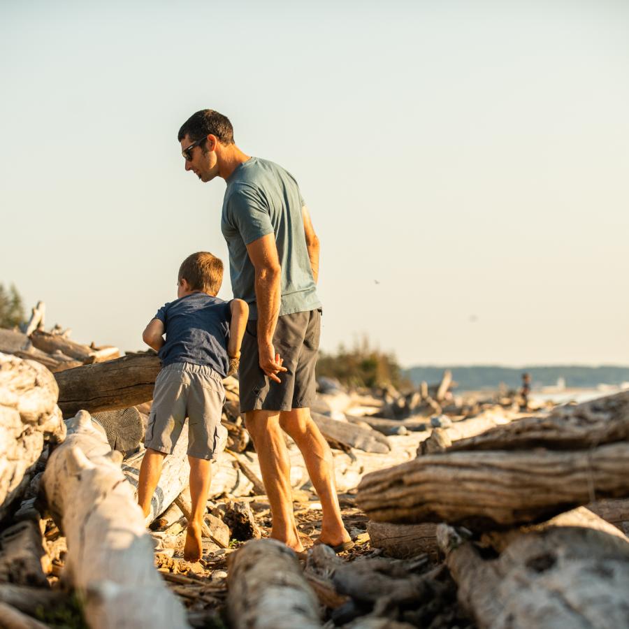 Man and child looking for something on the beach.