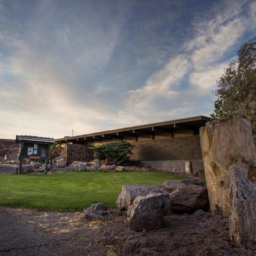 Side view of Gingko Petrified Forest interpretive center underneath blue cloudy sky.