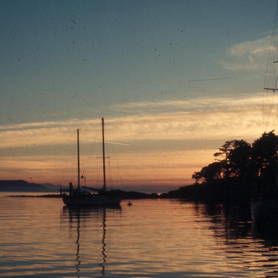 orange sunset over water reflecting back the fading sunlight with boat