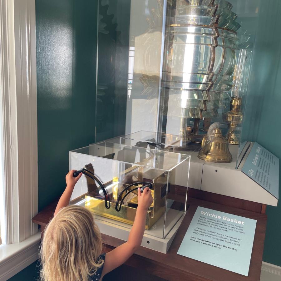 Child interacting with wickie box with lighthouse keeper tools.